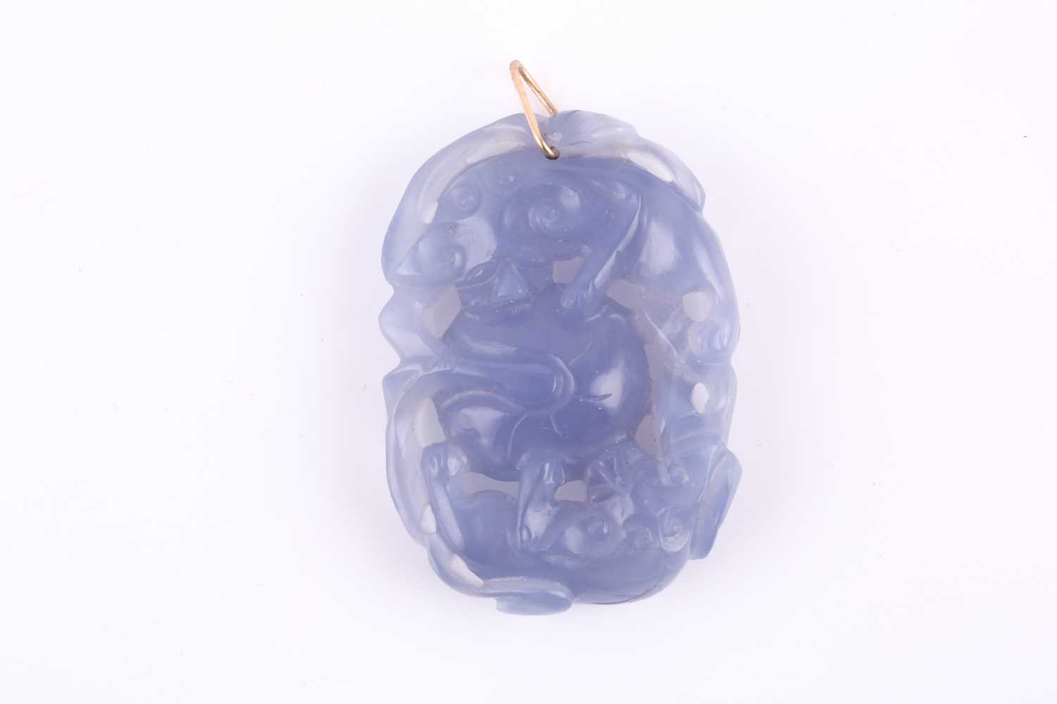 Lot 129 - A Chinese chalcedony carved pendant, of oval...