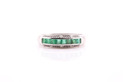 Lot 148 - An emerald and diamond half hoop eternity ring;...