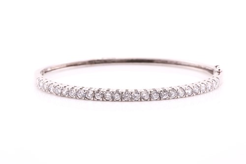 Lot 544 - A cubic zirconia bracelet; the hinged centre...