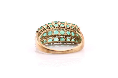 Lot 428 - A three-row emerald half hoop ring; the...