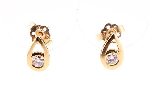 Lot 758 - A pair of single stone diamond earrings; the...