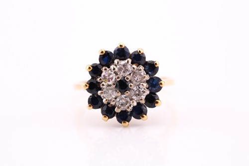 Lot 692 - A sapphire and diamond cluster ring, the...