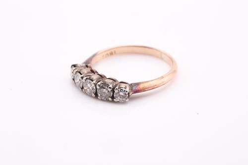 Lot 64 - A five stone diamond ring, on yellow metal...