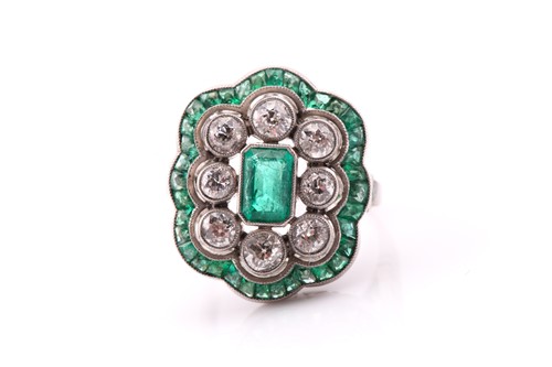 Lot 67 - An emerald and diamond cluster ring, the...