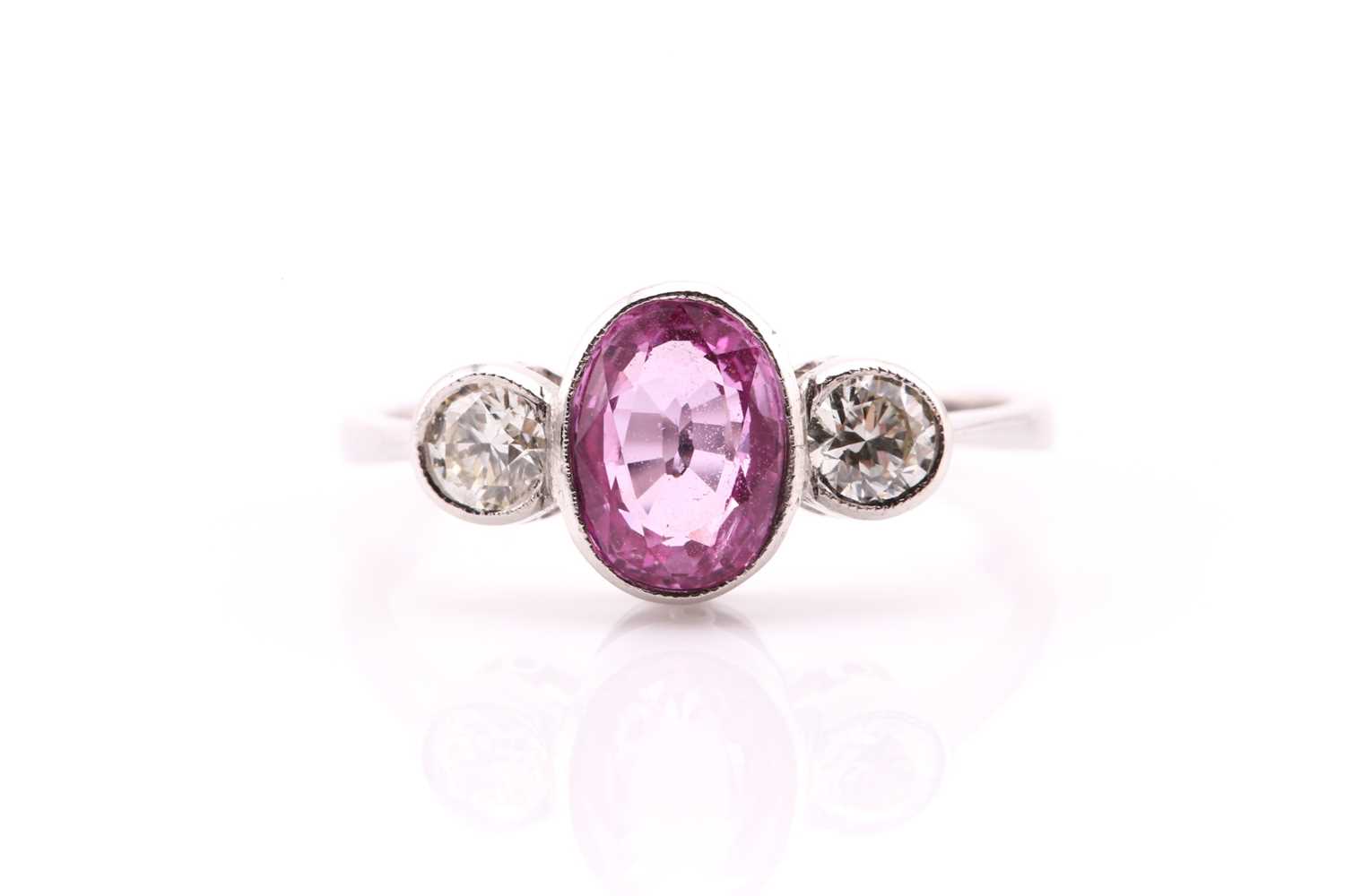 Lot 56 - A pink sapphire and diamond three stone ring...