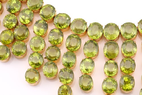Lot 103 - A peridot fringe necklace, oval and round cuts...