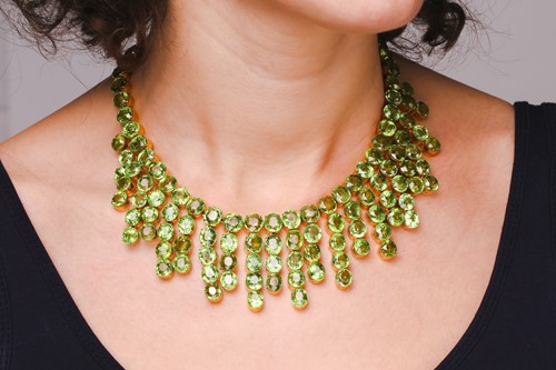 Lot 103 - A peridot fringe necklace, oval and round cuts...