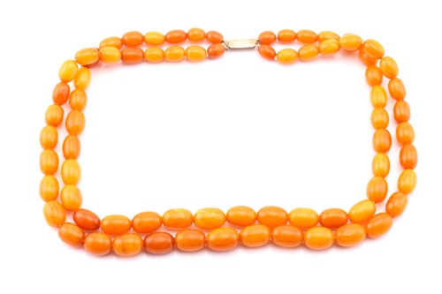 Lot 38 - An amber two strand bead necklace; the...