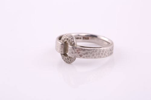 Lot 213 - A platinum ring and diamond ring; the looped...