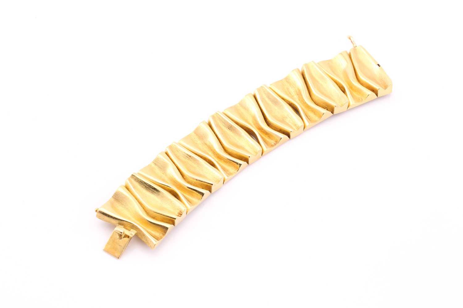Lot 333 - A yellow precious metal bracelet, designed as...