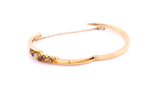 Lot 83 - A sapphire and diamond hinged bangle, the...