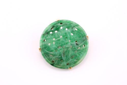 Lot 112 - A circular carved jade brooch, mid 20th...