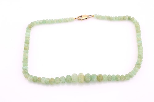 Lot 110 - A carved bead emerald necklace, the graduated...