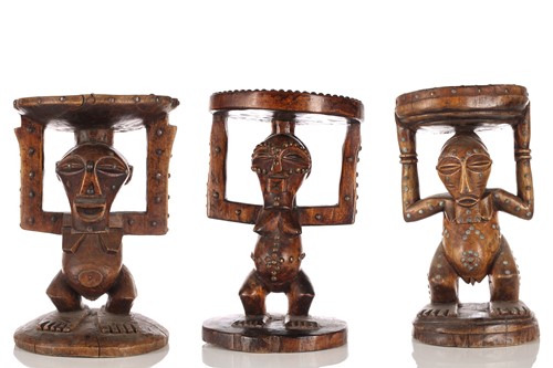 Lot 55 - Three Songye carved hardwood caryatid stools,...