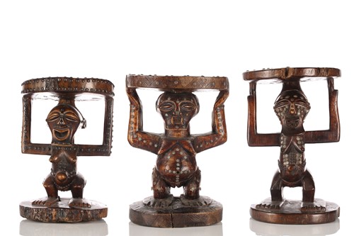 Lot 212 - Three Songye carved hardwood caryatid stools,...