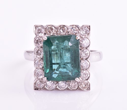 Lot 46 - An emerald and diamond halo ring, consisting...