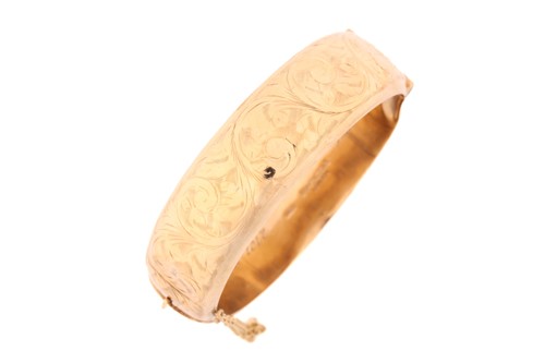 Lot 185 - A 9ct yellow gold hollow hinged bangle with...