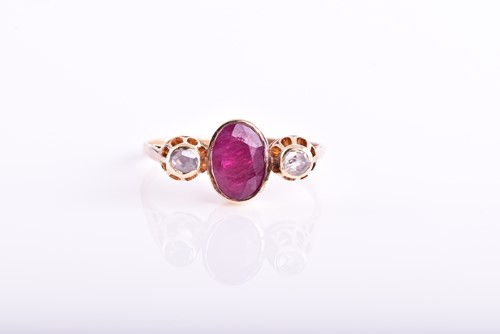 Lot 283 - A three stone ruby and diamond ring; the oval...