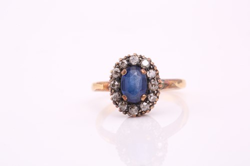 Lot 102 - A sapphire and diamond cluster ring; the oval...