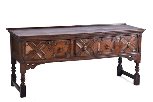 Lot 395 - A Charles II three drawer oak dresser base....