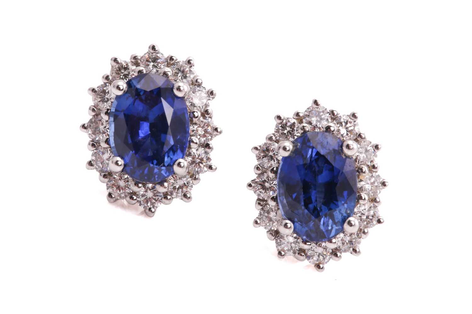 Lot 142 - A pair of sapphire halo earrings, each...