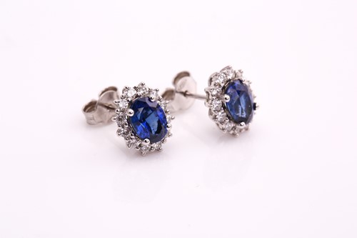 Lot 142 - A pair of sapphire halo earrings, each...
