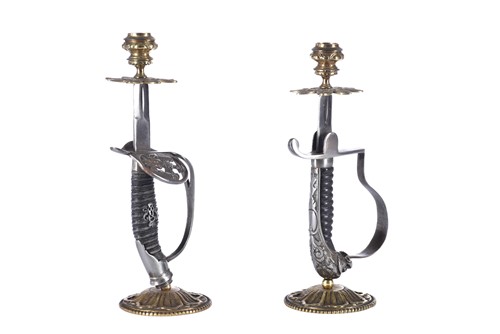 Lot 598 - A close pair of sword hilt candlesticks, one...