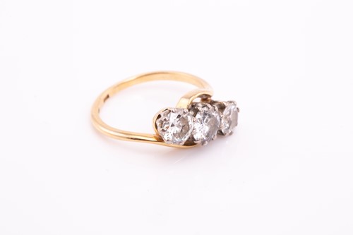 Lot 297 - A three stone diamond crossover ring; the...