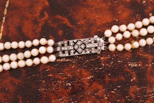 Lot 98 - A three-row cultured pearls necklace with an...