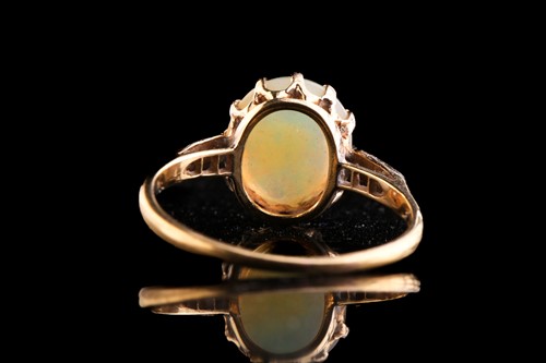Lot 246 - An opal ring with diamonds, comprises an oval...