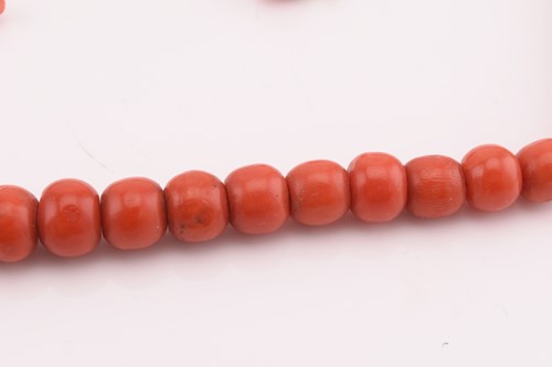 Lot 84 - A precious coral graduated bead necklace and a...