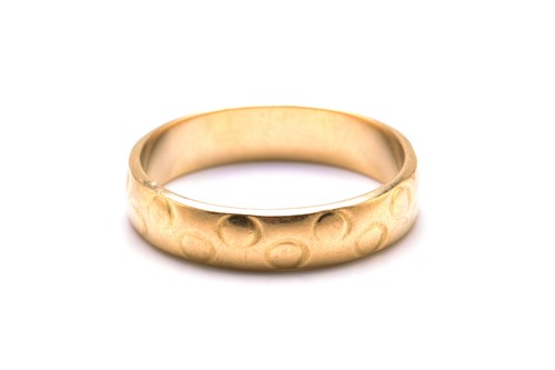 Lot 108 - An 18ct gold textured wedding ring, with a...