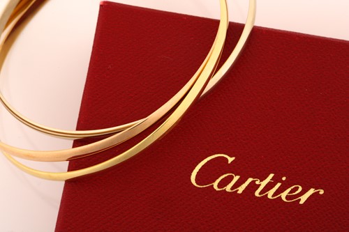 Lot 33 - A Cartier trinity bracelet, featuring three...