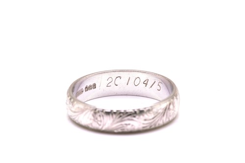 Lot 89 - A platinum engraved wedding band, with floral...