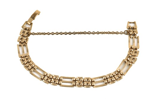 Lot 164 - A gate link bracelet in yellow metal, with a...