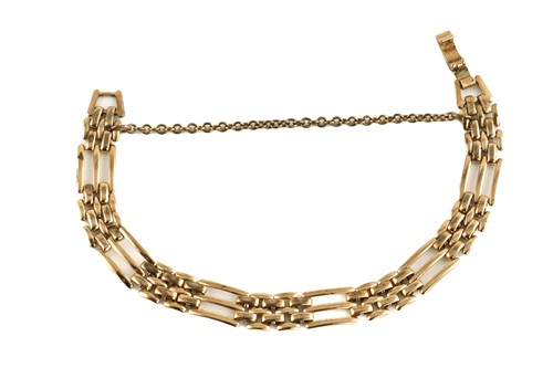 Lot 164 - A gate link bracelet in yellow metal, with a...