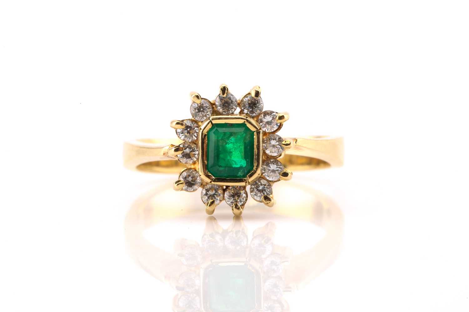 Lot 149 - An emerald and diamond cluster ring, featuring...