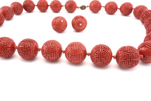 Lot 3 - A Chinese lacquer carved bead necklace and...