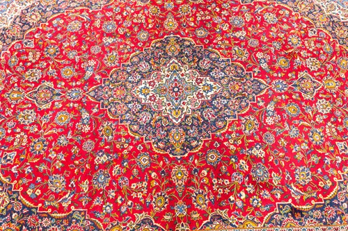 Lot 275 - A "Lacquer Red" ground room size Kashan carpet,...