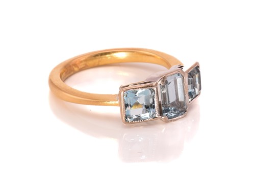 Lot 149 - A three-stone aquamarine ring, centred with a...