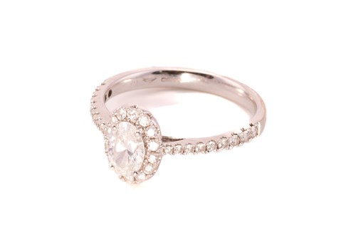 Lot 122 - An oval diamond entourage ring in 18ct gold,...