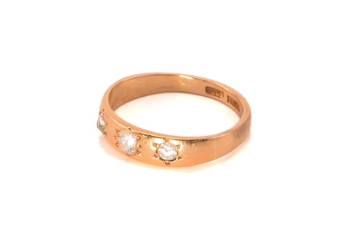 Lot 57 - A three-stone diamond ring; the slightly...