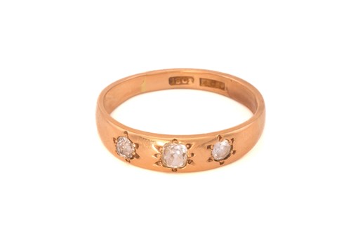 Lot 57 - A three-stone diamond ring; the slightly...