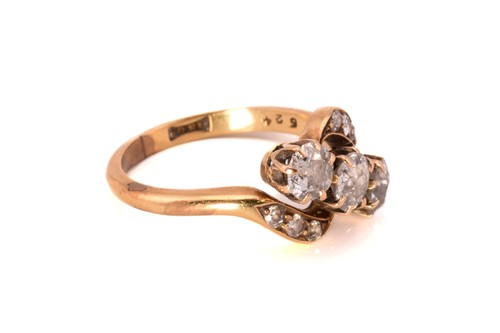 Lot 93 - A three-stone diamond bypass ring in yellow...