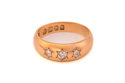 Lot 22 - A three-stone diamond gypsy ring in 18ct gold,...
