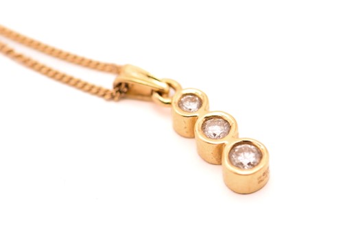 Lot 136 - An 18ct gold three-stone diamond pendant on...
