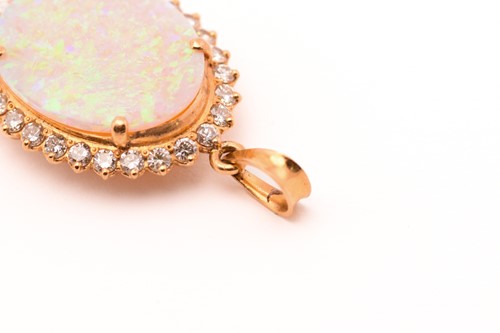 Lot 175 - An opal entourage pendant, featuring a white...