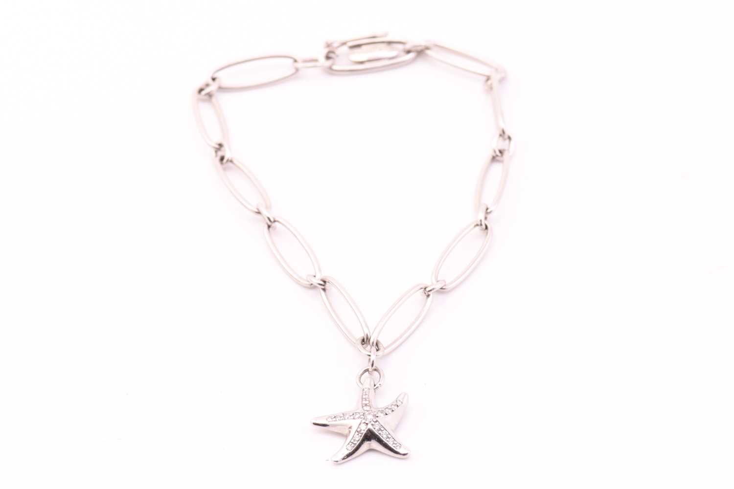 Lot 13 - Tiffany & Co. - A platinum charm bracelet with...