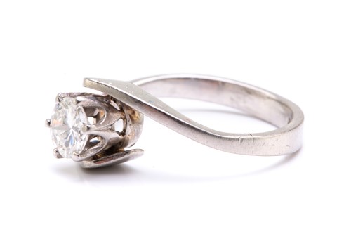 Lot 76 - A diamond solitaire bypass ring in platinum,...