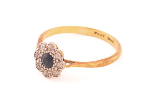 Lot 155 - A sapphire and diamond cluster ring, centred...